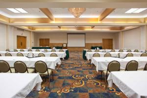 a conference room with white tables and chairs and a whiteboard at Holiday Inn Great Falls-Convention Center, an IHG Hotel in Great Falls