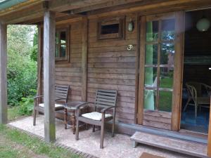 a cabin with a table and chairs on the porch at Bed & Happiness in Wichmond