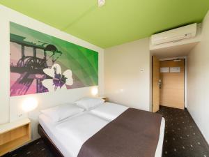 - une chambre avec un lit orné d'une peinture murale dans l'établissement B&B Hotel Bochum-Herne, à Herne