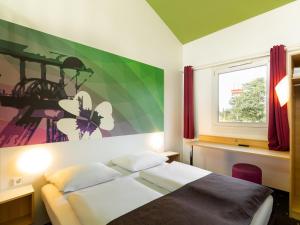 a bedroom with a bed and a window at B&B Hotel Bochum-Herne in Herne