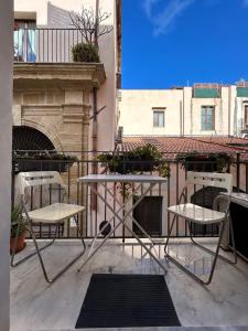 ein Paar Stühle und Tische auf dem Balkon in der Unterkunft Al Cassaro - holiday home in Palermo