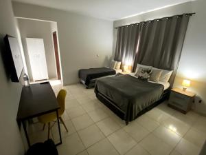 a hotel room with two beds and a desk at Prime Hotel in Arcos