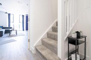 a staircase in a living room with a stair case at Hemel Apartments - Lilac Luxe in Hemel Hempstead