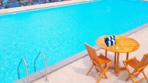 班達楠榜的住宿－武吉蘭杜餐廳酒店，游泳池旁的桌椅