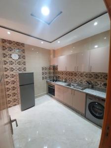 a large kitchen with a sink and a dishwasher at Appartement Maghrib Jadid in Larache