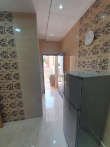 a kitchen with a stainless steel refrigerator in a room at Appartement Maghrib Jadid in Larache