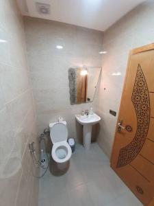 a bathroom with a toilet and a sink at Appartement Maghrib Jadid in Larache