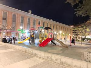 a park with a playground with slides and umbrellas at Apartamento con piscina in Benicarló