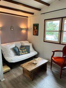 a room with a bed and a table and a chair at Chalet dans le vert in Gassin