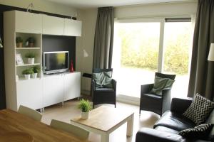 een woonkamer met een bank en een tafel bij Appartement Baken in Hollum