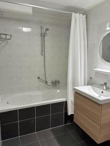 a bathroom with a shower and a tub and a sink at Appartement Baken in Hollum