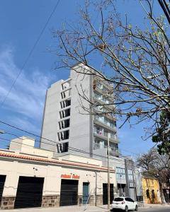 a tall white building with a car in front of it at Monoambiente turístico la linda de Salta in Salta