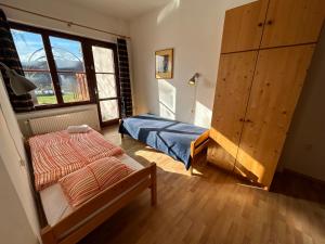 a bedroom with a bed and a large window at Penzion Maják in Dublovice