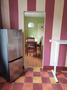 une cuisine avec une table et un réfrigérateur en acier inoxydable dans l'établissement Ruhrpott-Paradies, à Duisbourg