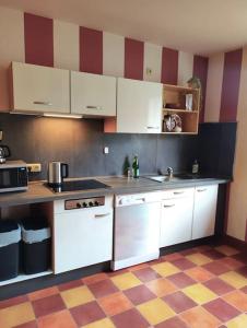 a kitchen with white cabinets and a checkered floor at Ruhrpott-Paradies in Duisburg