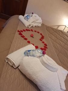 Una cama con una toalla blanca con rosas rojas. en GIRASOLE Wellness e Relax, en Fossano