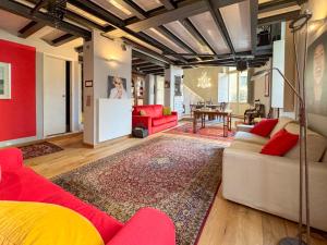 a living room with red chairs and a red couch at T-Loft in Genova