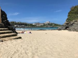 a beach with people laying on the sand at Tolcarne Guest House in Newquay