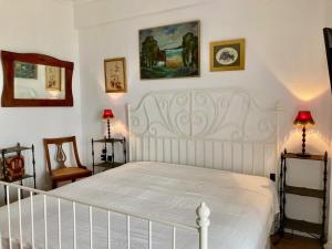 a bedroom with a white bed and two chairs at "Ariane" - Afytos village with sea view in Afitos