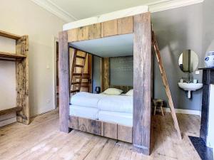 - duże drewniane łóżko piętrowe w pokoju z umywalką w obiekcie Clos des Rogations w mieście Saint-Hubert