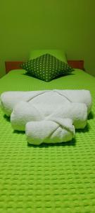 three towels are stacked on a green bed at OS.LITTLE.GREEN in Osijek