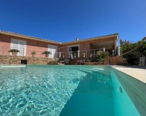 a swimming pool in front of a house at Villa BRIMI in Ghisonaccia