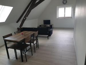 a dining room with a table and a piano at La Casa D'Augy in Farges-en-Septaine