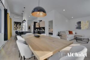 ein Esszimmer mit einem Holztisch und weißen Stühlen in der Unterkunft Achille - Boisé avec spa et sauna in Pont-Rouge + 28 Fotos