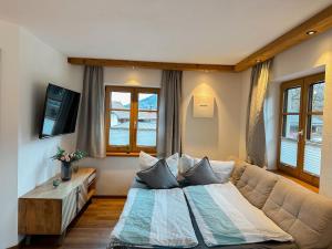 a bedroom with a large bed and a couch at Ferienwohnungen Gastager Hof in Ruhpolding