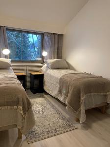 um quarto com 2 camas e uma janela em Pitkäkuusen rahkis em Lahti
