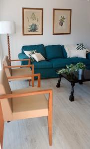sala de estar con sofá azul y mesa en Apartamento Tajinaste con vistas al mar y la montaña y wifi gratis, en Los Realejos
