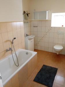 a bathroom with a bath tub and a toilet at Dom Wakacyjny JM in Prudnik