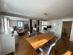 cocina y sala de estar con mesa de madera y sillas en Schöne Wohnung in Feldkirch, en Feldkirch