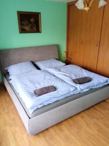 a bed with white sheets and two pillows on it at Dom Wakacyjny JM in Prudnik