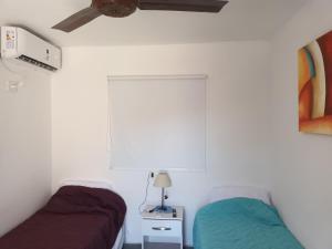 een slaapkamer met 2 bedden en een plafondventilator bij Wasi in Belén