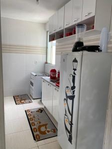 eine Küche mit einem Kühlschrank mit Bild darauf in der Unterkunft Apartamento mobiliado em Aracaju in Aracaju