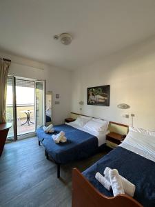 a hotel room with two beds and a balcony at Nuovo hotel ANTHISA in Lido di Savio