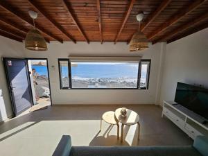 uma sala de estar com um sofá, uma mesa e uma televisão em Casa Playa Quemada junto al mar em Playa Quemada