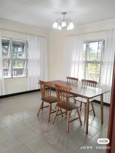 a dining room with a table and chairs and windows at 斐济楠迪机场民宿带空调 in Nadi