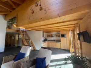 uma sala de estar com tectos em madeira e uma escadaria em Haus Sapporo em Grindelwald