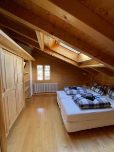 a bedroom with two beds in a room with wooden ceilings at Haus Sapporo in Grindelwald