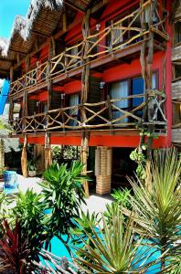 a resort with a red building with a balcony at Safari Natal Beach Hotel in Natal