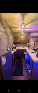 a kitchen with purple lights on the ceiling and a counter at شالية منتجع ارض السعادة 1 in Obhor