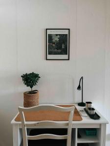 una scrivania con una pianta in vaso e una foto sul muro di Grindstugan - Centralt och trevligt hus i Nora a Nora