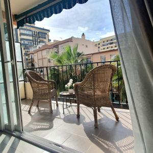 two wicker chairs and a table on a balcony at Studio in city in Fuengirola