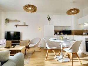 a kitchen and a living room with a table and chairs at La Pause Dorée d'Anne-Sophie in Bruz +45 photos