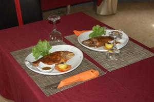 dois pratos de comida em cima de uma mesa em Melia's hotel em Sali Nianiaral