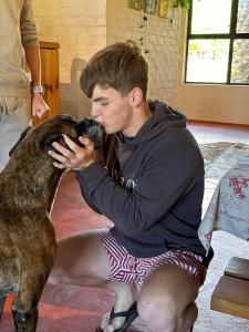 Ein junger Mann spielt mit einem Hund in der Unterkunft Bella Manga Country Escape in Plettenberg Bay