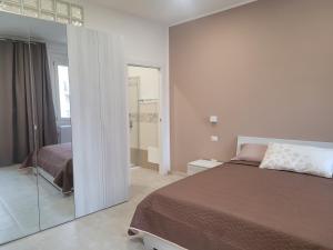 - une chambre avec un lit et un mur en verre dans l'établissement Domo Azuni, à Sassari