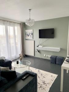 un soggiorno con divano e tavolo di 2 Chambres - 6pers - 10 min gare - proche Paris - lac d'Enghien - casino à proximité a Épinay-sur-Seine